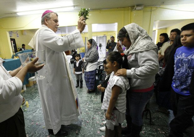 Bishop John Manz blesses Guatemalan workers and families following Mass in Boaz, Alabama.